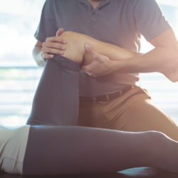 Physiotherapist giving knee therapy to a woman